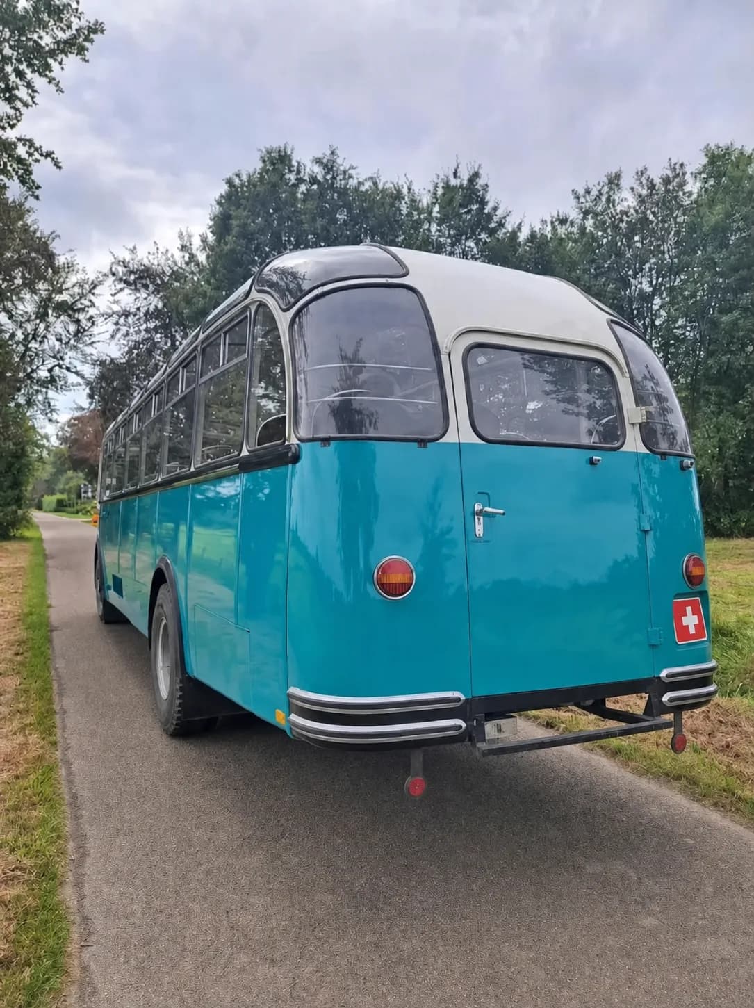 The Swiss Montessori School Bus seen from behind on a forest lane